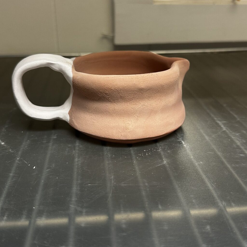 Creamer with two different glazes applied before the final firing.